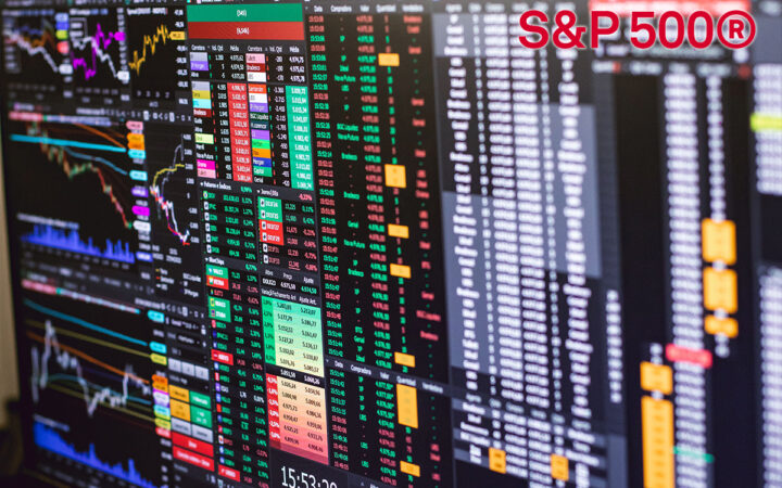 Multiple monitor displays showing stock charts, data tables, and a red S&P 500® logo in the top-right corner.